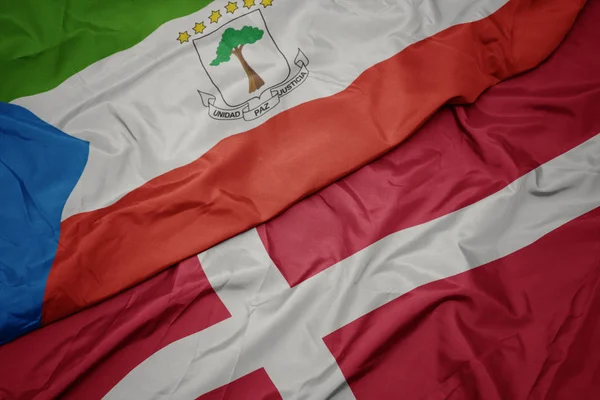 Machanie kolorową flagą denmarku i flagą narodową Gwinei Równikowej. — Zdjęcie stockowe