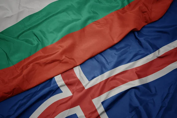 Viftar med färgrik flagg från Island och nationell flagga bulgarien. — Stockfoto