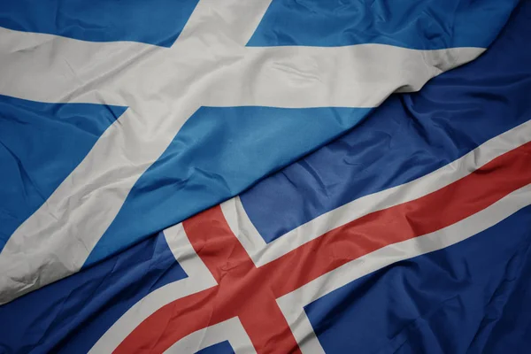 Zwaaiende vlag van IJsland en nationale vlag van Schotland. — Stockfoto