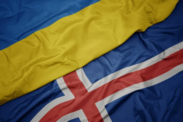 Zwaaiende vlag van IJsland en nationale vlag van ukraïne. — Stockfoto