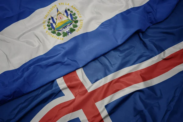 Acenando bandeira colorida de Islândia e bandeira nacional de el salvador . — Fotografia de Stock