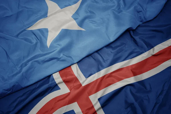 Viftar med färgrik flagg från Island och nationell flagga från Somalia. — Stockfoto