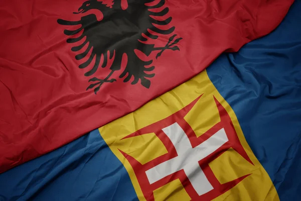 Sventolando bandiera colorata di madeira e bandiera nazionale di albania . — Foto Stock