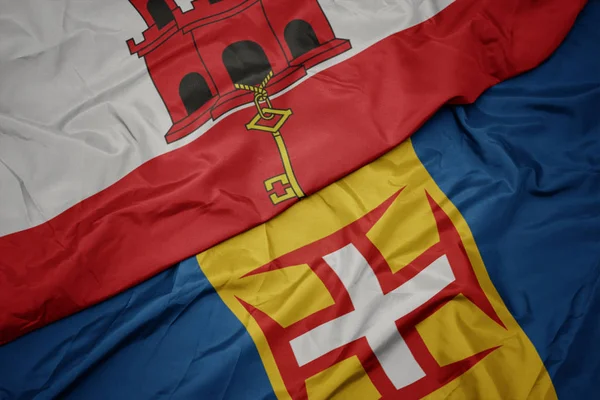 A madeira színes lobogója és a gibraltári nemzeti zászló lobogtatása. — Stock Fotó