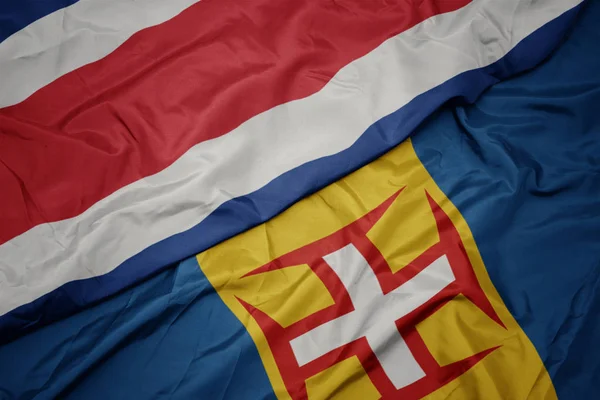 Zwaaiende vlag van madeira en nationale vlag van costa rica. — Stockfoto