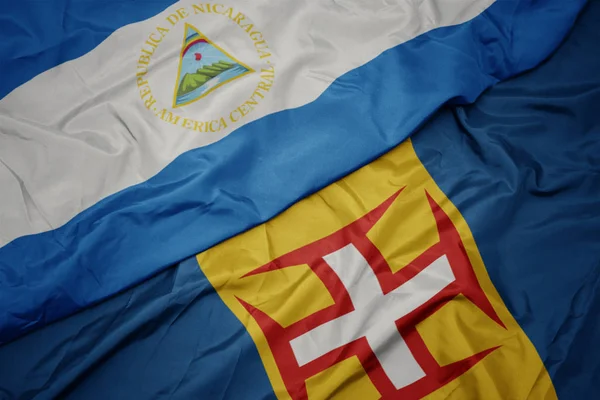 Κυματίζει πολύχρωμη σημαία της Madeira και εθνική σημαία της nicaragua. — Φωτογραφία Αρχείου