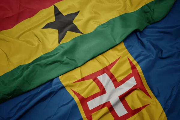 Zwaaiende vlag van madeira en nationale vlag van ghana. — Stockfoto