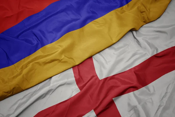 waving colorful flag of england and national flag of armenia.