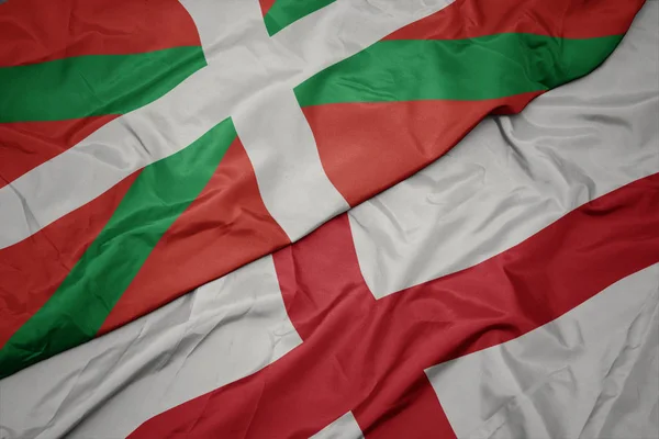 Schwenken bunte Flagge Englands und Nationalflagge des Baskenlandes. — Stockfoto