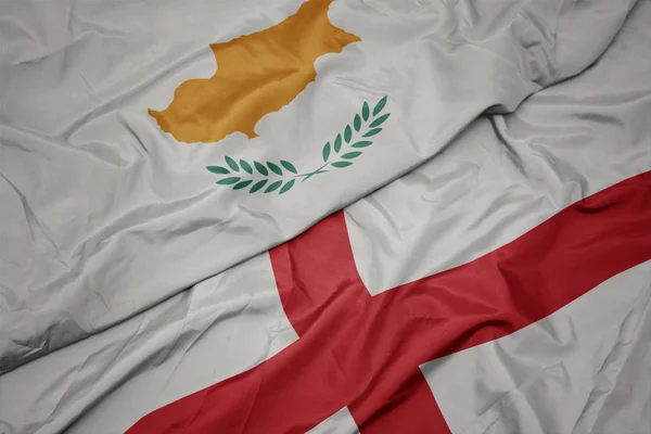 waving colorful flag of england and national flag of cyprus