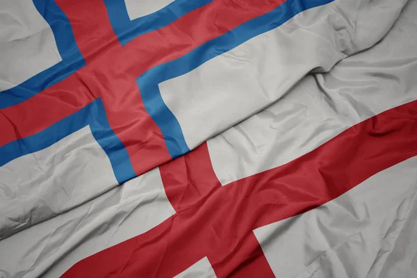 Schwenken bunte Flagge Englands und Nationalflagge der Färöer-Inseln. — Stockfoto