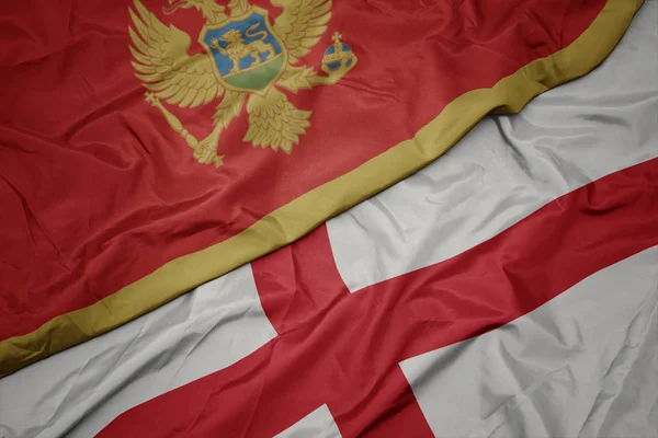 waving colorful flag of england and national flag of montenegro.