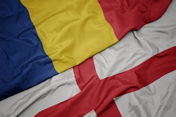 Acenando bandeira colorida da inglaterra e bandeira nacional da Romênia . — Fotografia de Stock
