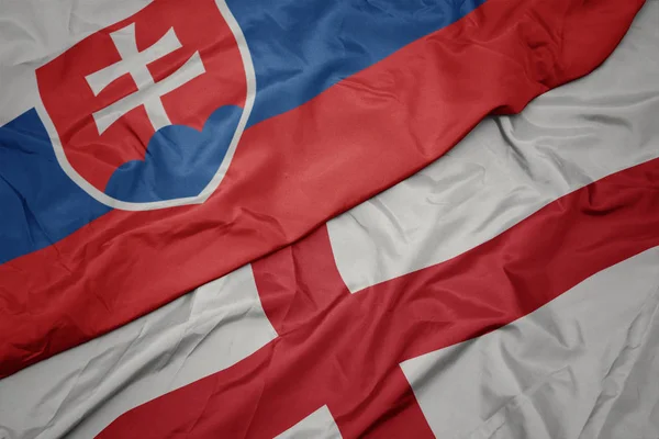 Waving colorful flag of england and national flag of slovakia. — Stock Photo, Image