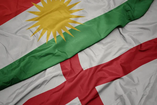waving colorful flag of england and national flag of kurdistan.