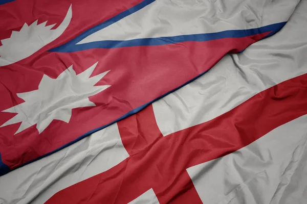 waving colorful flag of england and national flag of nepal.