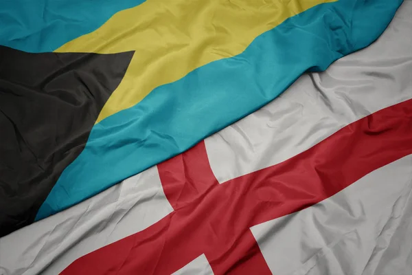 Agitant drapeau coloré de l'Angleterre et drapeau national des bahamas . — Photo