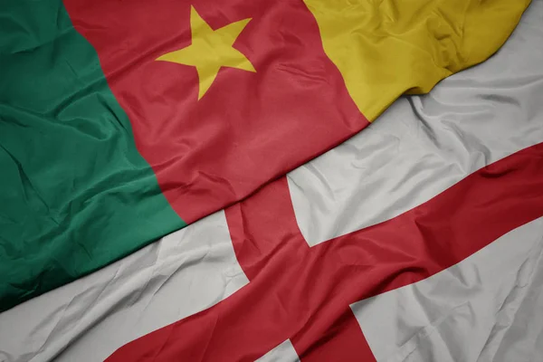 Ondeando colorida bandera de Inglaterra y bandera nacional de Camerún . — Foto de Stock