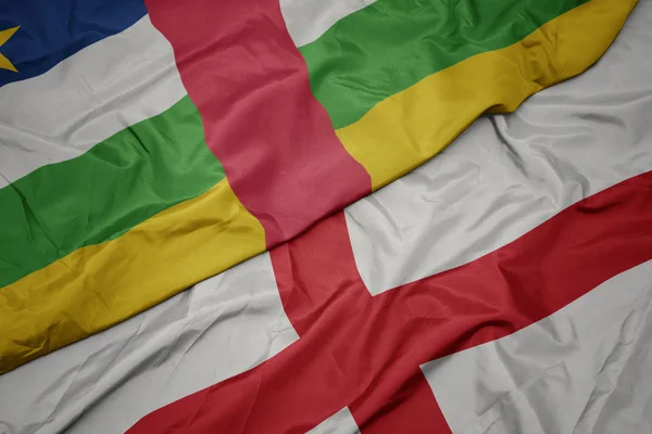 Agitant le drapeau coloré de l'Angleterre et le drapeau national de la République centrafricaine . — Photo