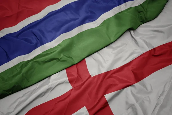 Sventolando bandiera colorata dell'Inghilterra e bandiera nazionale della Gambia . — Foto Stock