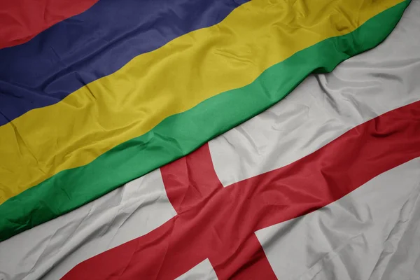 waving colorful flag of england and national flag of mauritius.