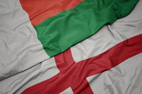 Waving colorful flag of england and national flag of madagascar. — Stock Photo, Image