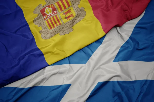 waving colorful flag of scotland and national flag of andorra.