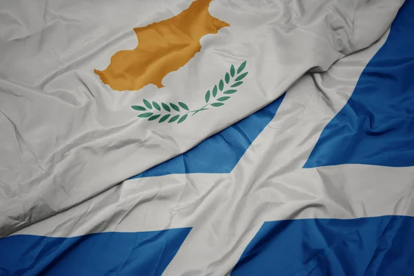 waving colorful flag of scotland and national flag of cyprus.