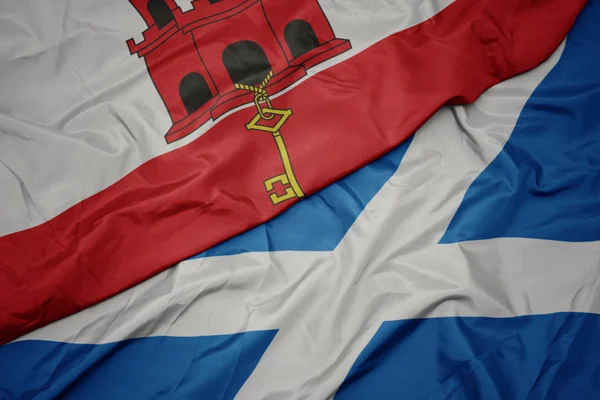 Skócia színes lobogója és a gibraltári nemzeti zászló lobogtatása. — Stock Fotó