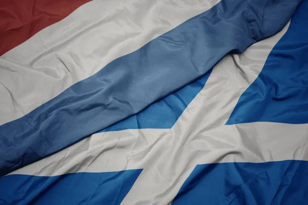 挥动着五彩缤纷的苏格兰国旗和豪华的国旗. — 图库照片