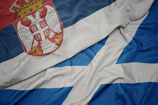 Waving colorful flag of scotland and national flag of serbia. — Stock Photo, Image