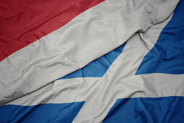 Sventolando bandiera colorata della Scozia e bandiera nazionale dell'indonesia . — Foto Stock