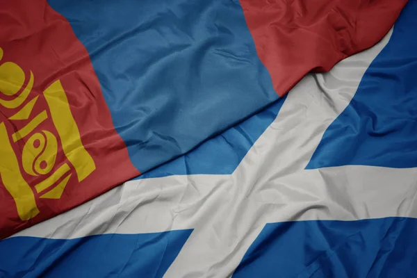 waving colorful flag of scotland and national flag of mongolia.