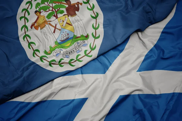 Waving colorful flag of scotland and national flag of belize. — Stock Photo, Image