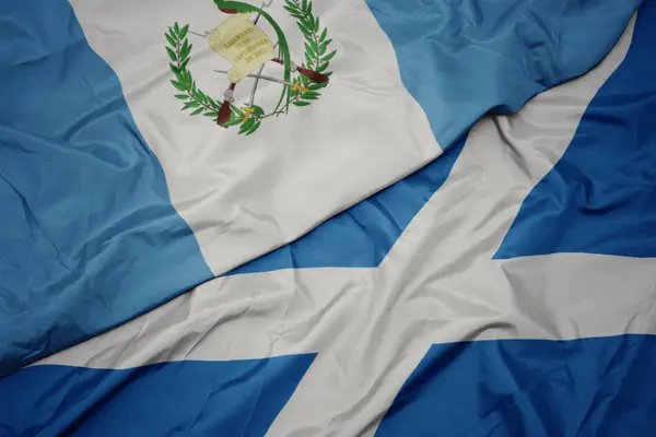 Mávání barevnou vlajkou Skotska a národní vlajkou Guatemaly. — Stock fotografie