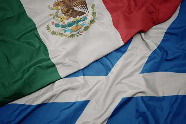 waving colorful flag of scotland and national flag of mexico.