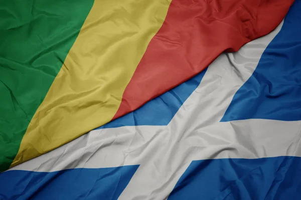 waving colorful flag of scotland and national flag of republic of the congo.