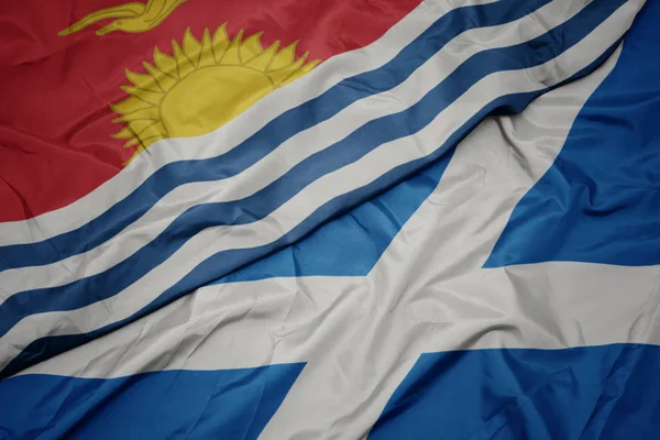 waving colorful flag of scotland and national flag of Kiribati .