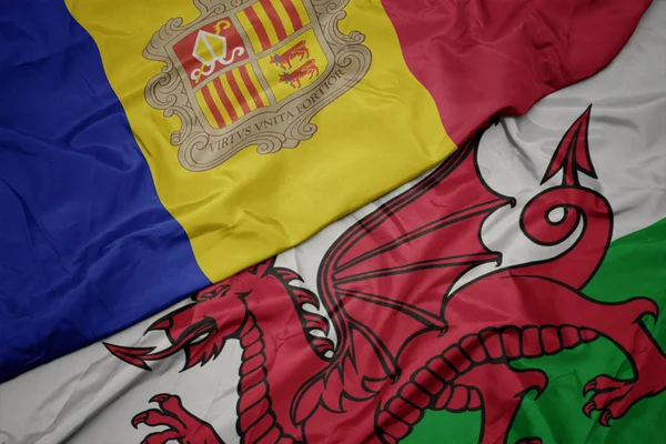 Размахивая красочным флагом Уэльса и национальным флагом андорры . — стоковое фото