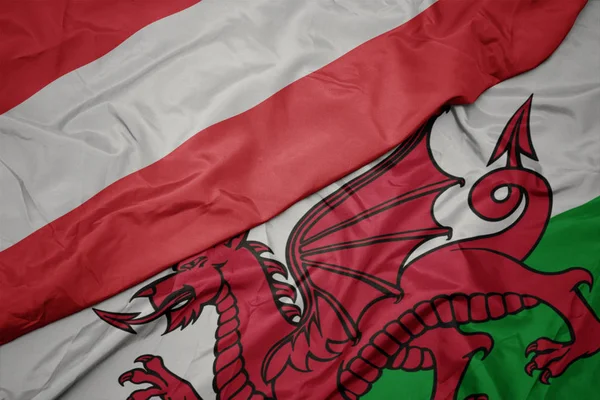 Színes walesi zászló lobogtatása és Ausztria nemzeti zászlója. — Stock Fotó