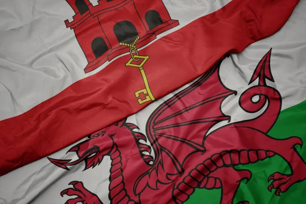 Falująca kolorowa flaga Walii i flaga narodowa Gibraltaru. — Zdjęcie stockowe