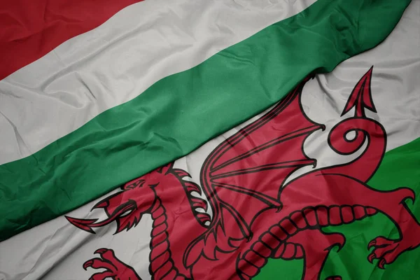 Waving colorful flag of wales and national flag of hungary. — Stock Photo, Image