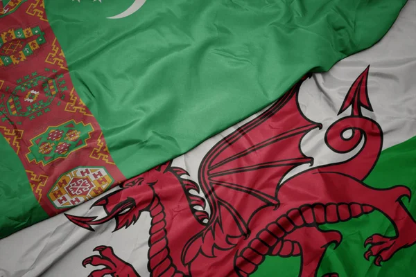 Mávající barevnou vlajkou Walesu a národní vlajkou Turkmenistánu. — Stock fotografie