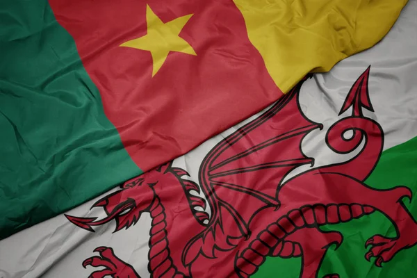 Waving colorful flag of wales and national flag of cameroon. — Stock Photo, Image