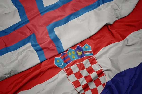 Ondeando colorida bandera de croacia y bandera nacional de las islas Feroe . — Foto de Stock