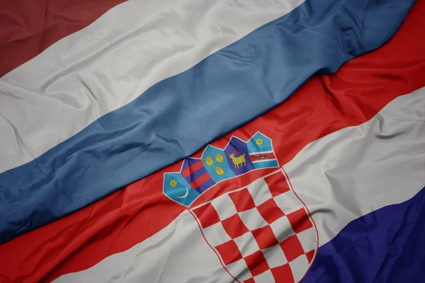 Ondeando colorida bandera de croacia y bandera nacional de luxembourg . — Foto de Stock