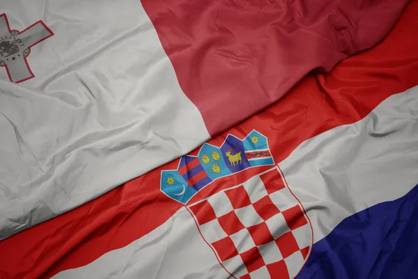 Mávající barevnou vlajkou Chorvatska a národní vlajkou sladu. — Stock fotografie