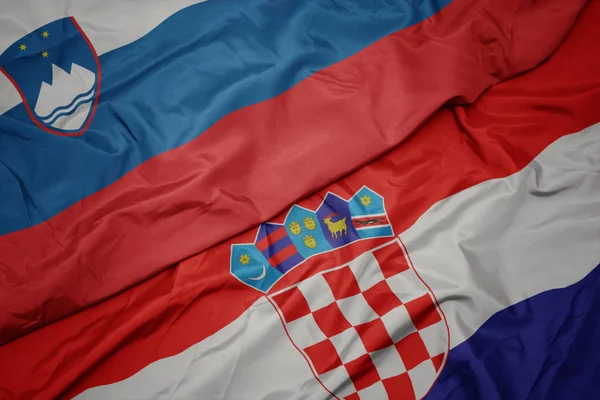 Ondeando colorida bandera de croacia y bandera nacional de slovenia . — Foto de Stock