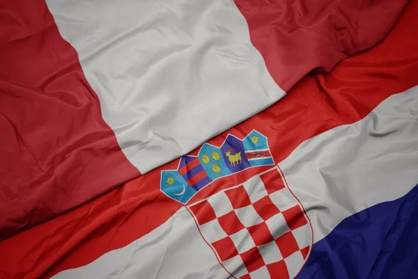 Agitant le drapeau coloré de la croatie et le drapeau national du Pérou . — Photo