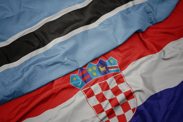 Agitant drapeau coloré de la croatie et drapeau national du Botswana . — Photo
